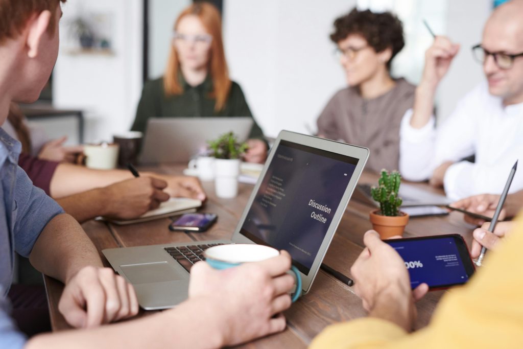pexels-photo-3184660-3184660 A diverse group of professionals collaborating with laptops and tablets in a modern office setting.